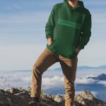 Modelo con sudadera verde botella y diseño Gutenberg.